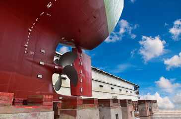 Detail stern and ship close up propeller, rudder red after maintenance already by surveyor in floating dry dock in shipyard Thailand