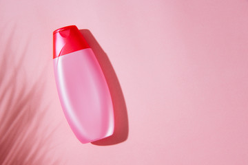Top view of female hair shampoo bottle mockup, isolated against pink background with available copy space.