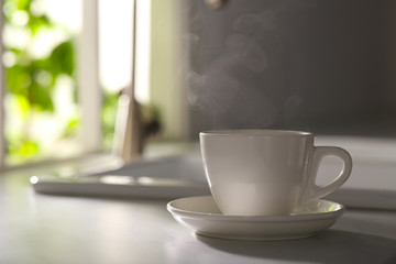 Cup of delicious coffee on kitchen countertop, space for text. Good morning