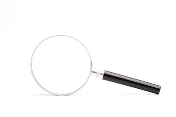A magnifying glass that is leaned on a white surface isolated white background.