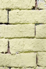 Background - fragment of a brick wall covered with textured rough stucco painted in green color