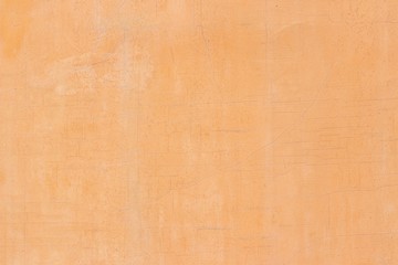 Background - fragment of a smooth wall with orange stucco and thin cracks