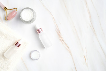 SPA natural cosmetic on marble background. Flat lay, top view organic body cream, bottles with...
