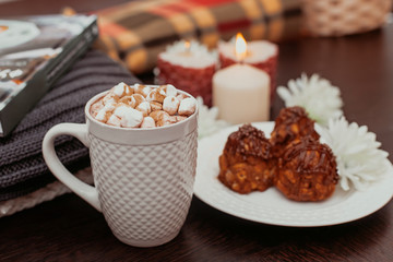 cake anthill on a plate on the table, cocoa with marshmallow in a white mug, home comfort