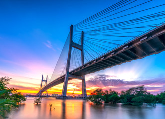 Fototapeta na wymiar Beautiful sunset landscape at Phu My Bridge. This largest cable-stayed bridge crossing Saigon river connect District 2 and 7 in Ho Chi Minh City, Vietnam