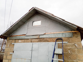 Repair of pediment of the house. Steel pediment on the garage. Roof repair.