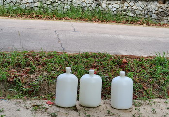 Grosses bonbonnes d'eau au bord de la route. (Thailande).