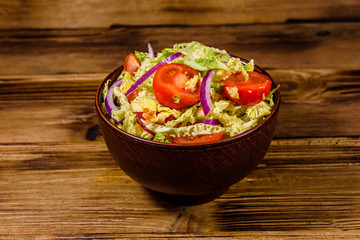 Vegan salad with savoy cabbage, tomatoes and onion in a ceramic bowl