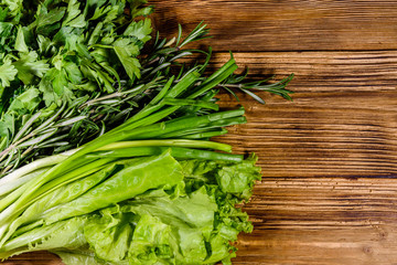 Lettuce rosemary and parsley on a wooden table. Vegan food. Top view
