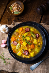 Rustic pea soup with bacon and sausages