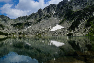 Naklejka na ściany i meble Reflection of rocky peaks in Georgiyski lakes near Sinanitsa in Pirin mountain National park in Bulgaria 