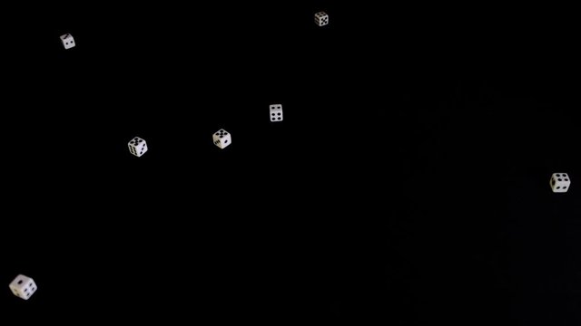 Falling, flying out white cubes on a black background. Dice fall, rotate and bounce on a black surface. Stops in sight.Concept of business and casino or gambling.Close-up.Slow mo, slo mo, slow motion