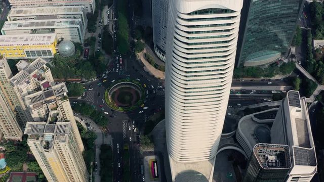 Fly over downtown office buildings with circle traffic intersection road in early morning, Guangzhou, Guangdong, China