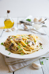 Spaghetti pasta with mushrooms, creamy sause and parsley on white