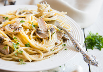Spaghetti pasta with mushrooms, creamy sause and parsley on white