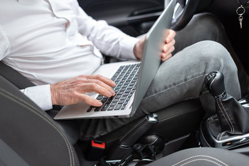 Businessman using his laptop in car