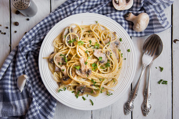 Spaghetti pasta with mushrooms, creamy sause and parsley on white