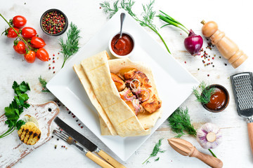 Chicken kebab with onions in pita bread. Meat skewers. Top view.