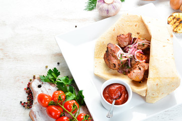 Veal kebab with onions in pita bread. Meat skewers. Top view.