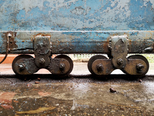 The castors of the old blue iron doors are rusted in wet and dirty floor