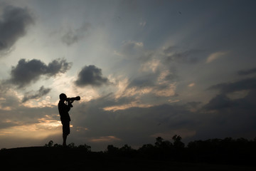 silhouette of a photographer in the sunset