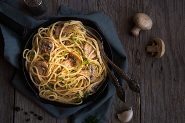 Spaghetti pasta with mushrooms, creamy sause and parsley on dark