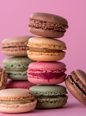Colorful Macaron, French confectioner cake in different flavors on a purple background.