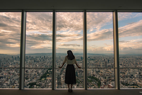 アベノハルカスからの夕焼け。それを眺める少女の後ろ姿。