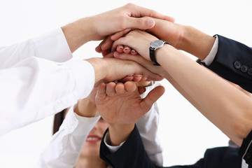 Group of people in suits crossed hands in pile