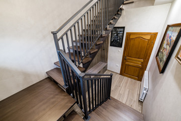 Wooden dark oak stairs with matte metal railings. Handmade stairs and railings. Modern style and...