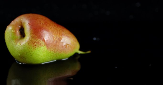 Single ripe pear rotates slowly on the table.