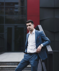 Young handsome caucasian man in suit standing in city