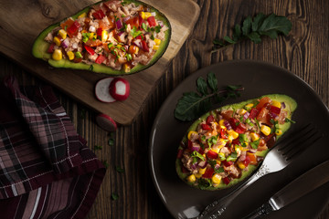 Avocado halves stuffed with tuna fish and vegetables