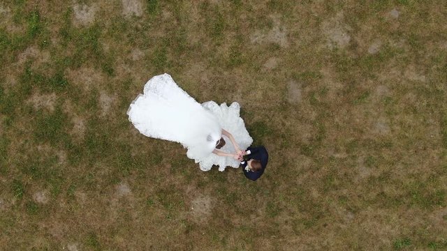 Wedding couple. The bride hugges the groom and takes his hand. Bride and groom embracing outdoors. Man and woman in love. Lovely groom and bride. Wedding day.