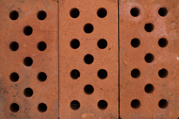 Three brown bricks with many small holes. for background
