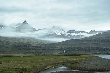 Waterfall under snowy mountains