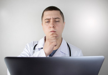 Workplace of a doctor. Male therapist works at a computer. The concept of modern medicine and technology used by medical professionals