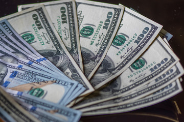 A stack of paper American dollars, photographed in close-up.