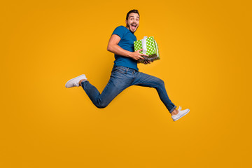 Fototapeta na wymiar Full length body size view of his he nice attractive crazy overjoyed cheerful cheery guy jumping holding in hands giftbox isolated over bright vivid shine vibrant yellow color background