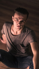 Obraz premium guy in a gray t-shirt sitting on the floor top view