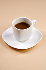 Cup of coffee with milk on beige background