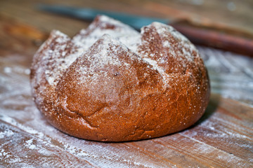 Traditional bread with a crust on a wooden board