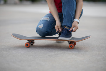 Skateboarder tying shoelace at outdoors