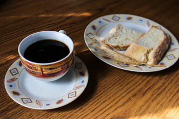Poranna świeżo parzona kawa z chlebem i pszenicą na talerzu w tle - obrazy, fototapety, plakaty