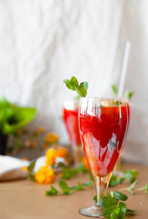 Crystal bakery with a drink, homemade cold juice with mint with fresh berries on a light background. Selective focus.