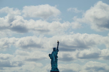 Statue of Liberty or Lady Liberty in New York City with dramatic clouds