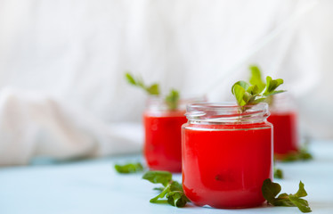 Glasses of homemade cold juice with mint with fresh berries on a light background. Selective focus.
