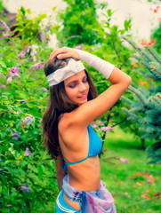 Model looking Girl standing in a swimsuit on the background of green grass and forest.