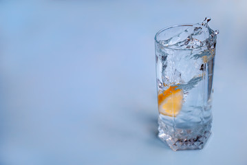 A splash of water in a glass due to a fallen lemon