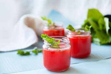 Glasses of homemade cold juice with mint with fresh berries on a light background. Selective focus.